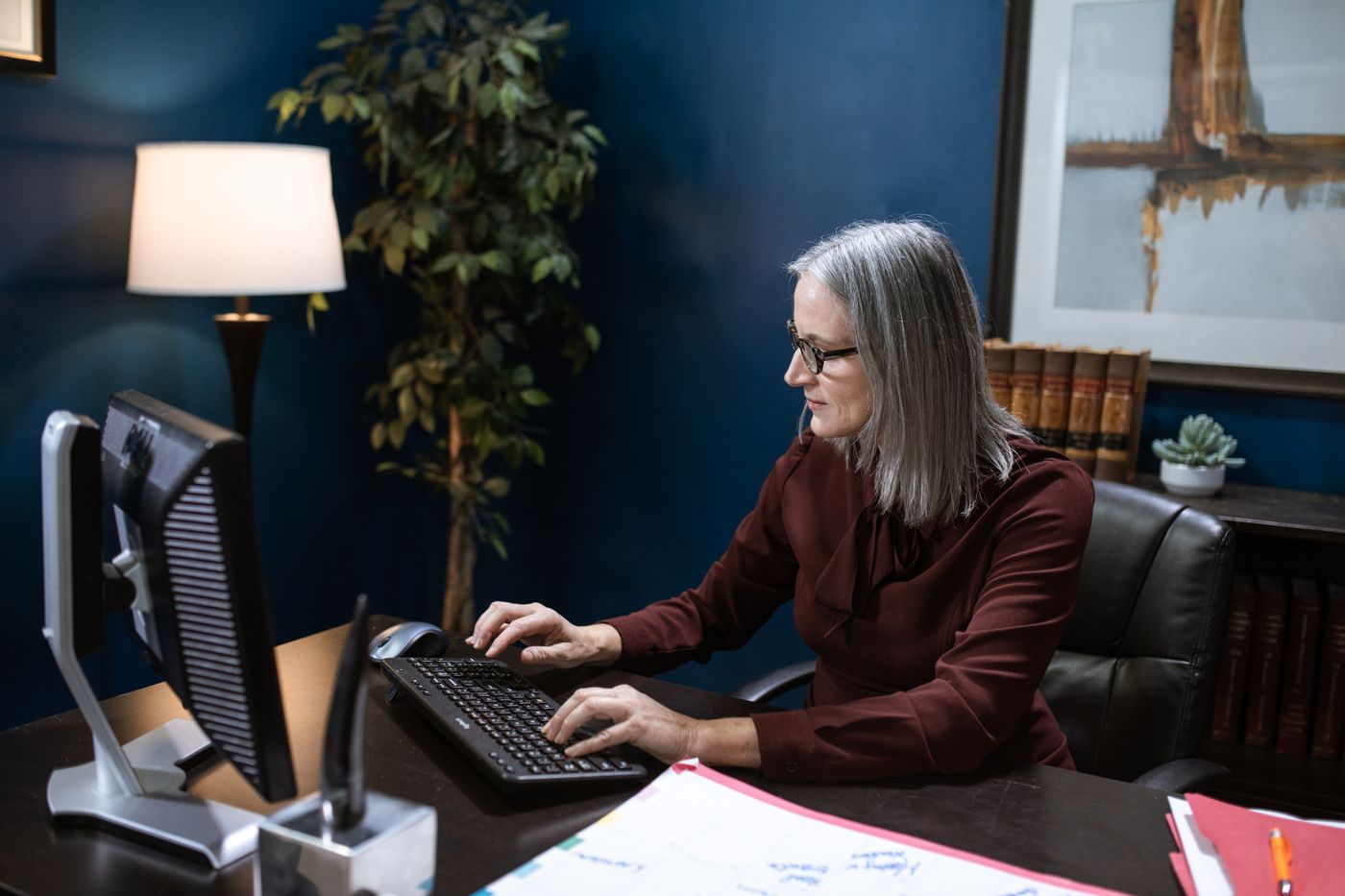 A fleet manager typing at a desk computer