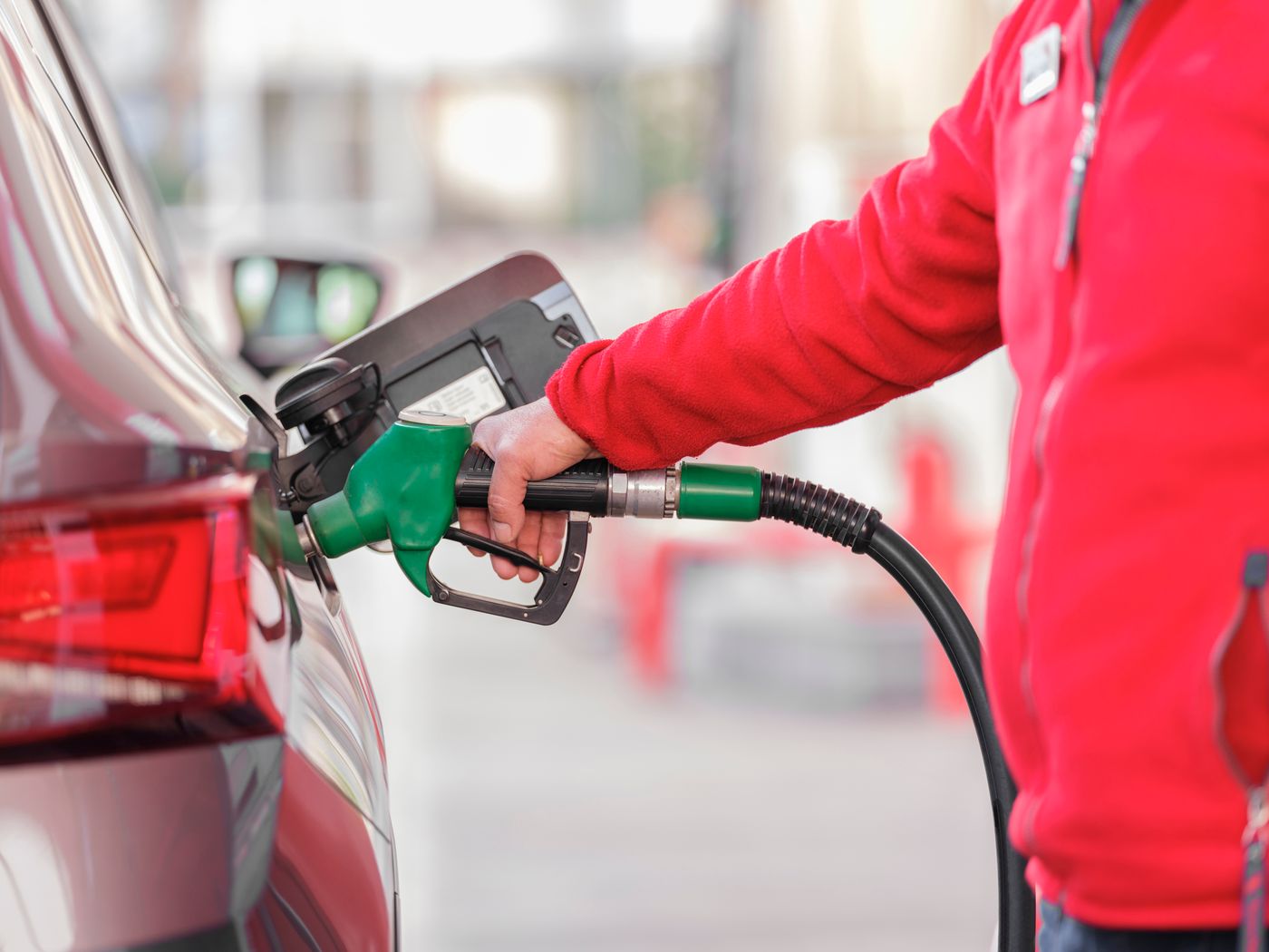 A driver filling a vehicle at a fuel pump