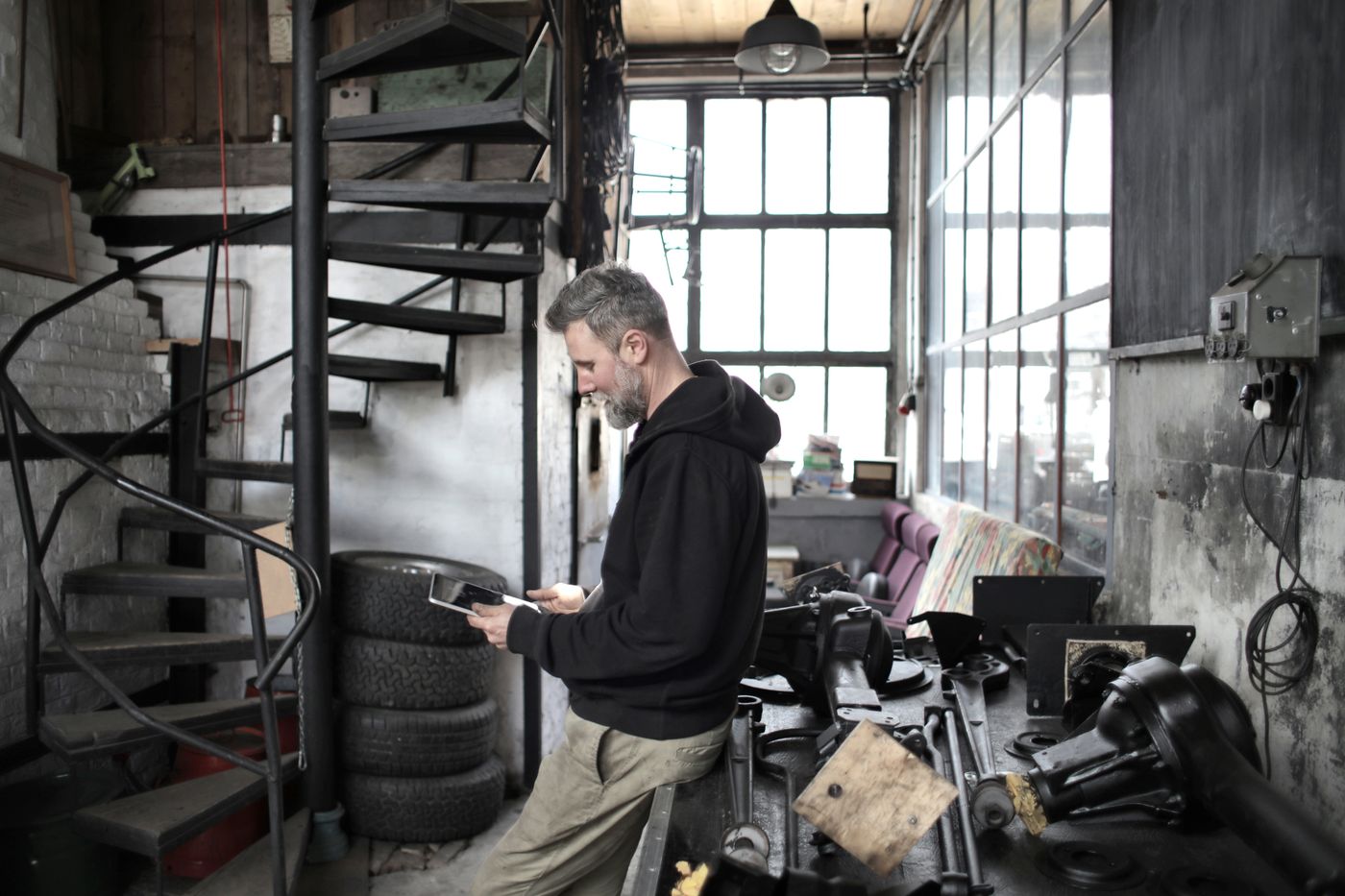 A mechanic reading a tablet in a workshop